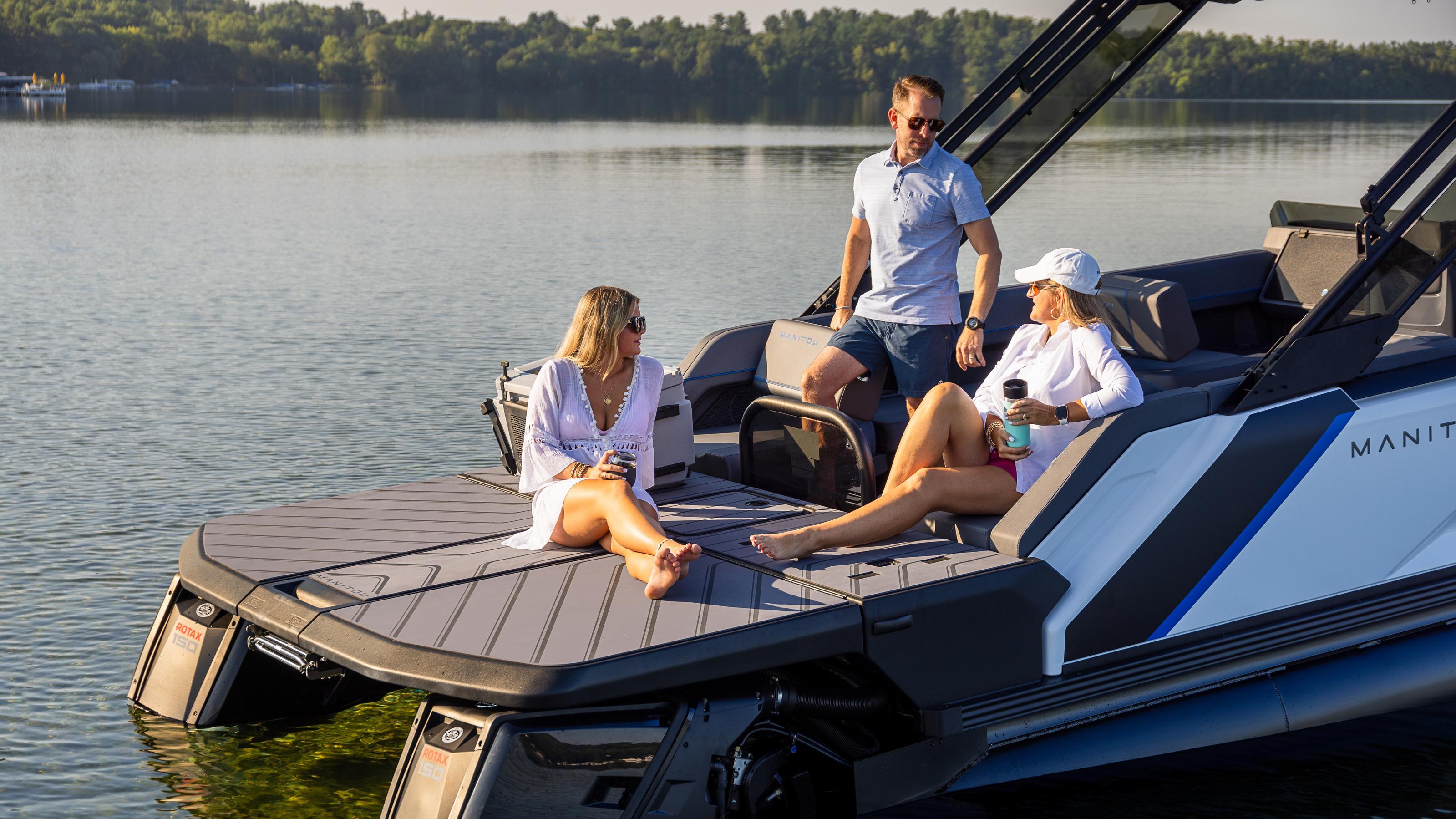 A family chatting on a Max Deck available on Manitou Explore pontoons