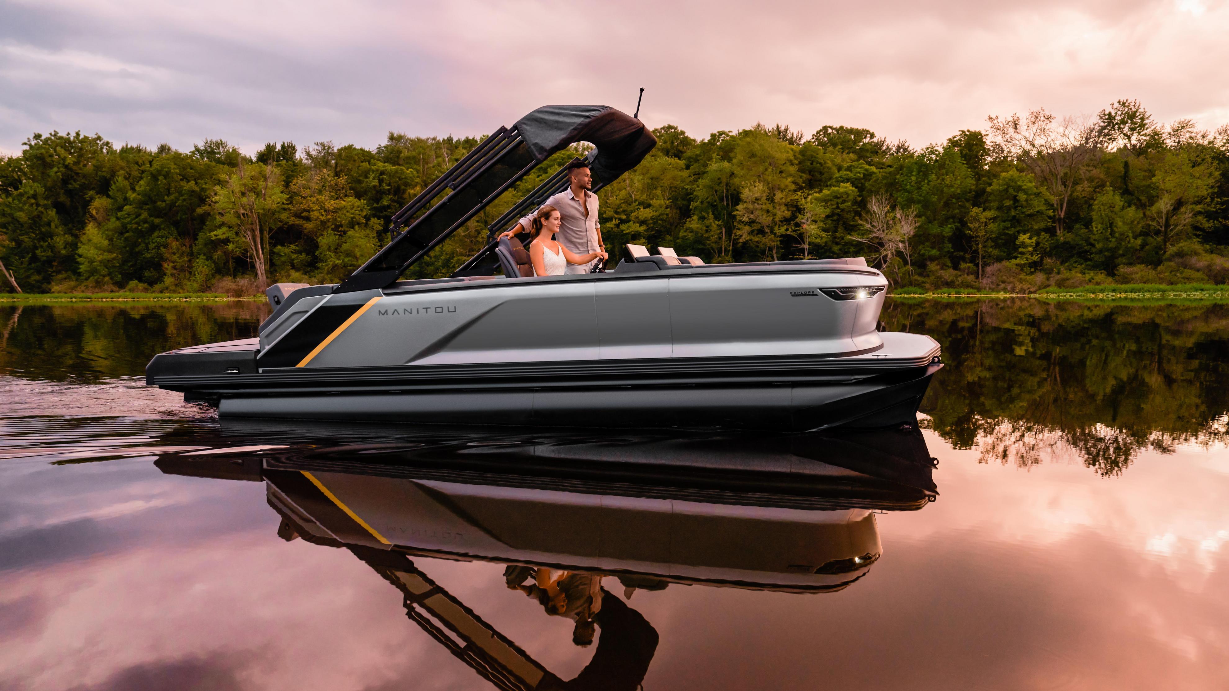 View of a couple on a Manitou Explore Switchback sailing in calm water.