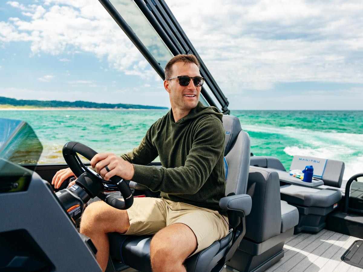 Kirk Cousins driving a Manitou Explore pontoon boat