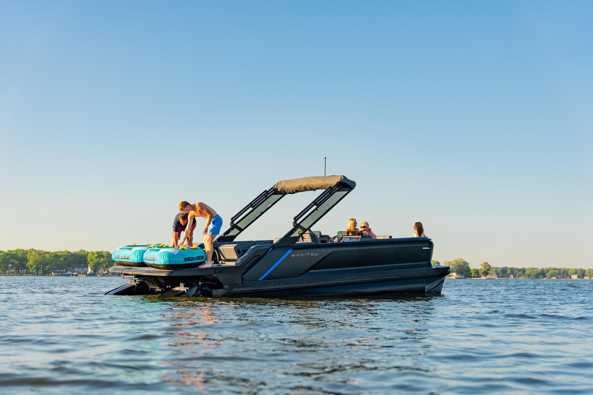 A family ready for water sports aboard their Manitou Explore 2025 pontoon boat 