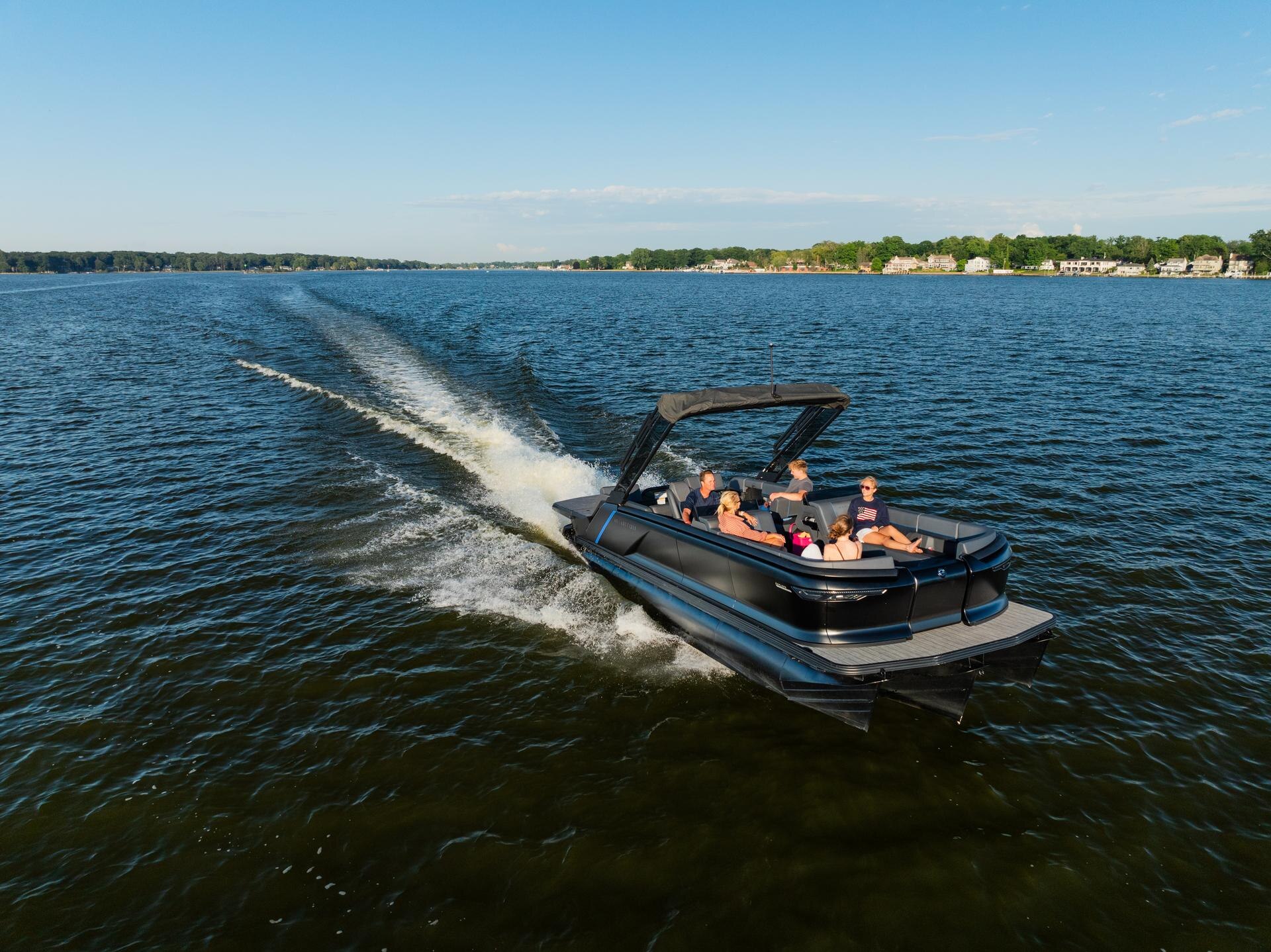 Family cruising on a lake on a Manitou Explore MAX with Dual Rotax S 150