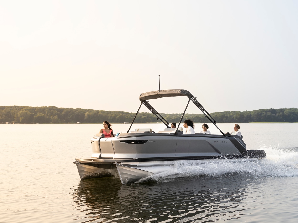 Une famille sur un Manitou Cruise MAX maintenant offert avec coque à deux flotteurs